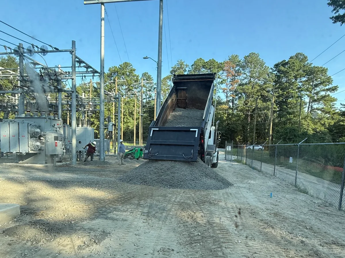Dump truck spreading gravel on a utility site